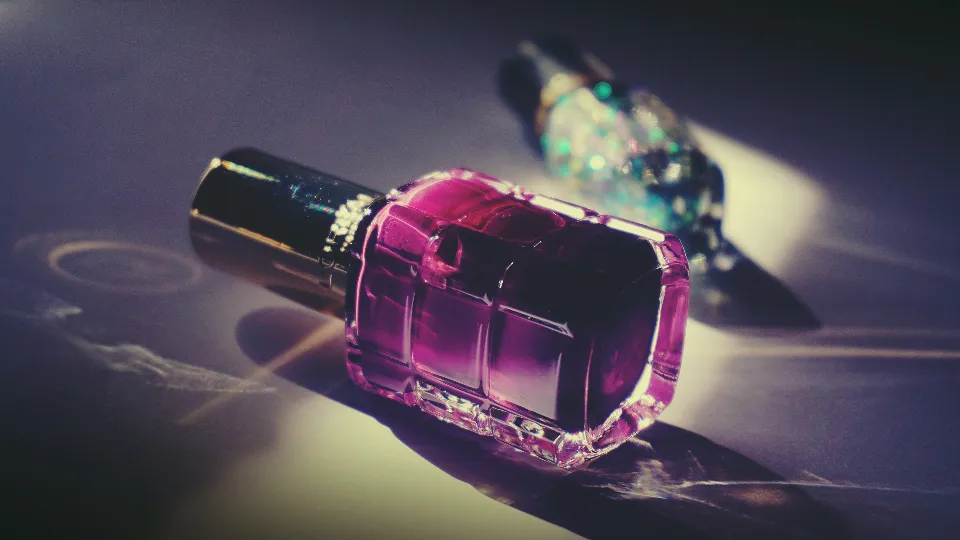 Violetter Nagellack in einer Glasflasche im Gegenlicht